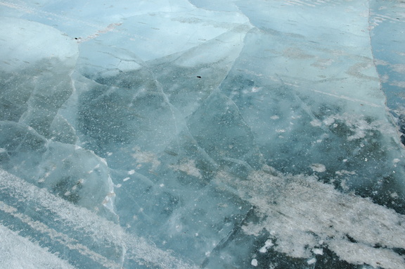 Трещины во льду и следы гусеничной техники